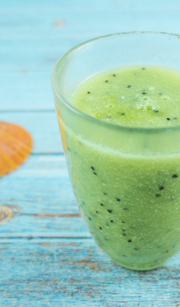 Фруктовый зеленый смузи на голубом столе