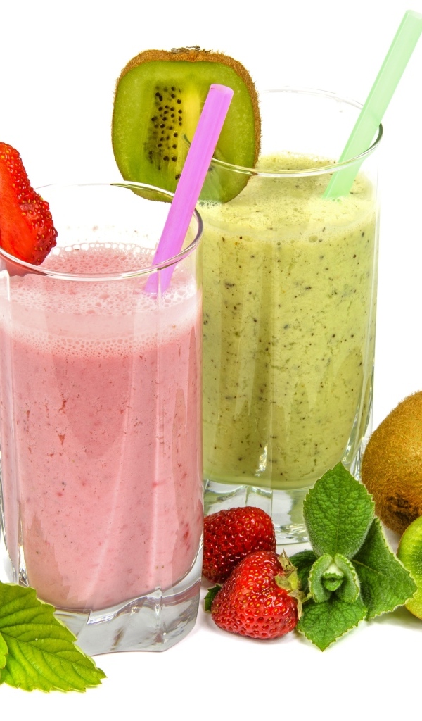 Фруктовые коктейли в стаканах на столе с клубникой и киви