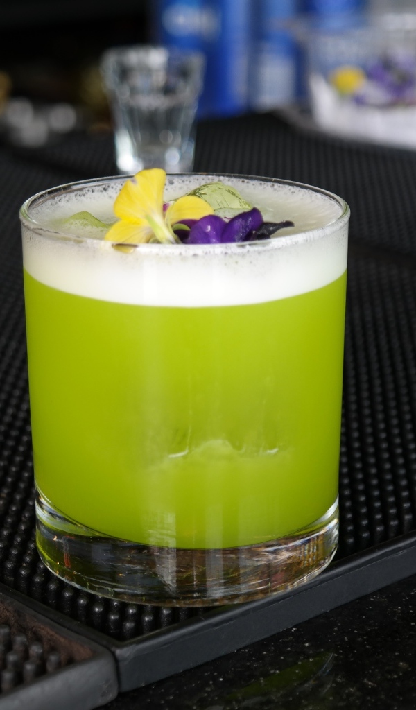Зеленый коктейль в стакане с цветами