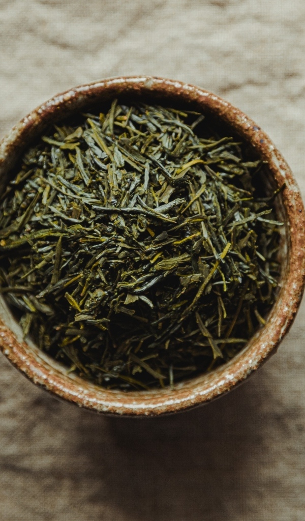 Зеленый чай в пиале на столе с чайником