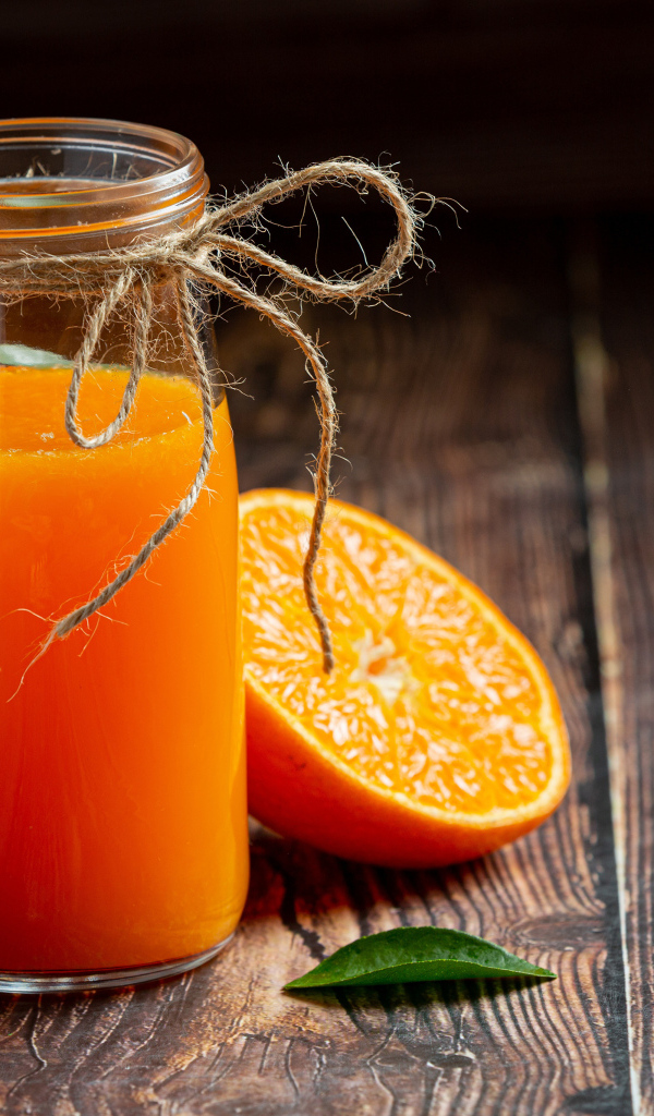 Банка свежего сока на столе с мандаринами