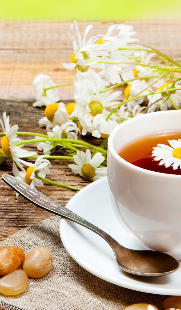 Чай на столе с цветами ромашки и конфетами
