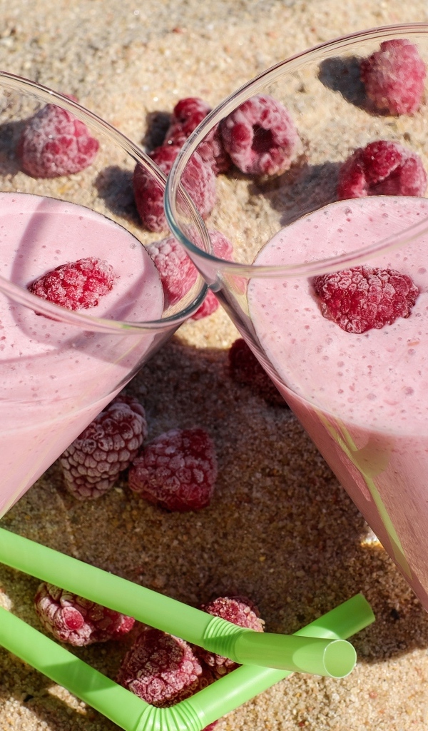 Два стакана ягодного смузи с малиной на песке 