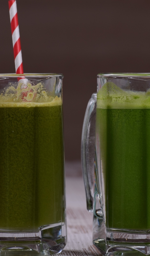 Два стакана зеленого смузи с трубочками