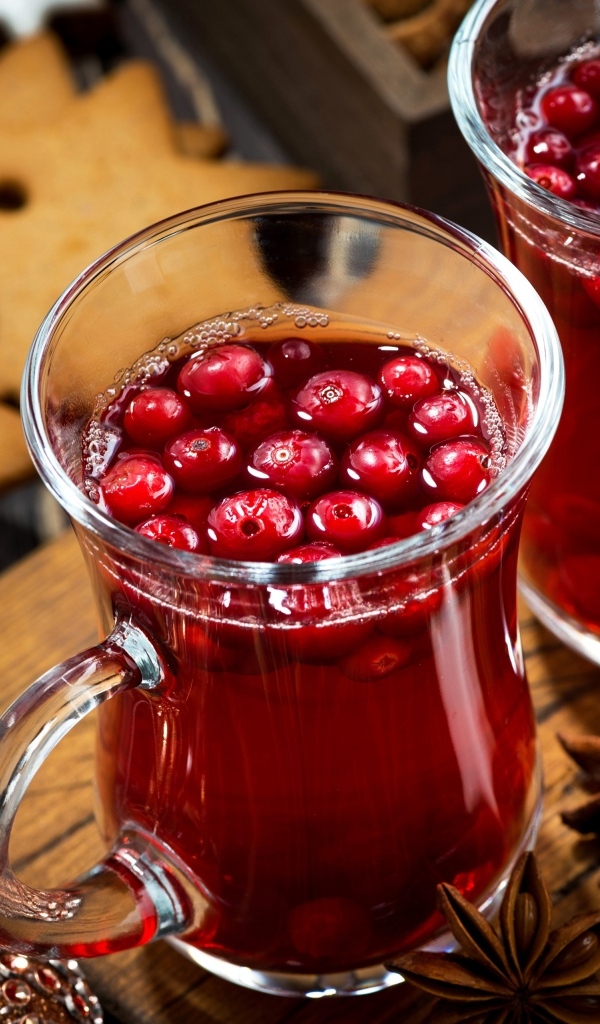 Две кружки клюквенного морса на столе с печеньем