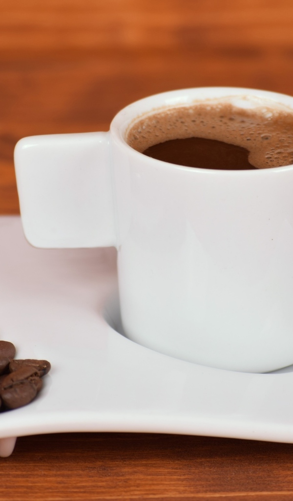 Белая чашка горячего кофе на столе 