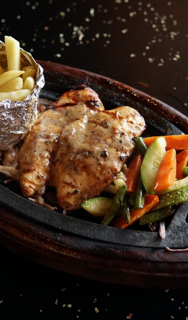 Жареная курица с картофелем фри и салатом на тарелке