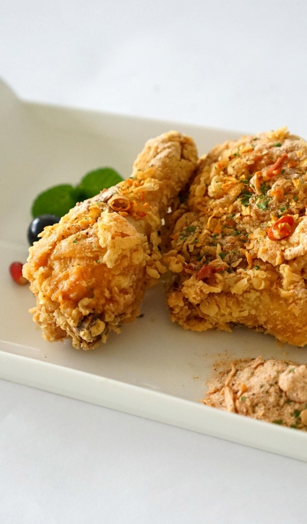 Жареная хрустящая курица в тарелке на столе