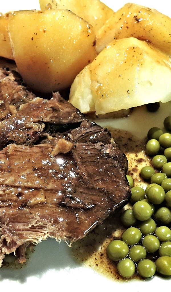 Кусок мяса с картофелем и зеленым горошком