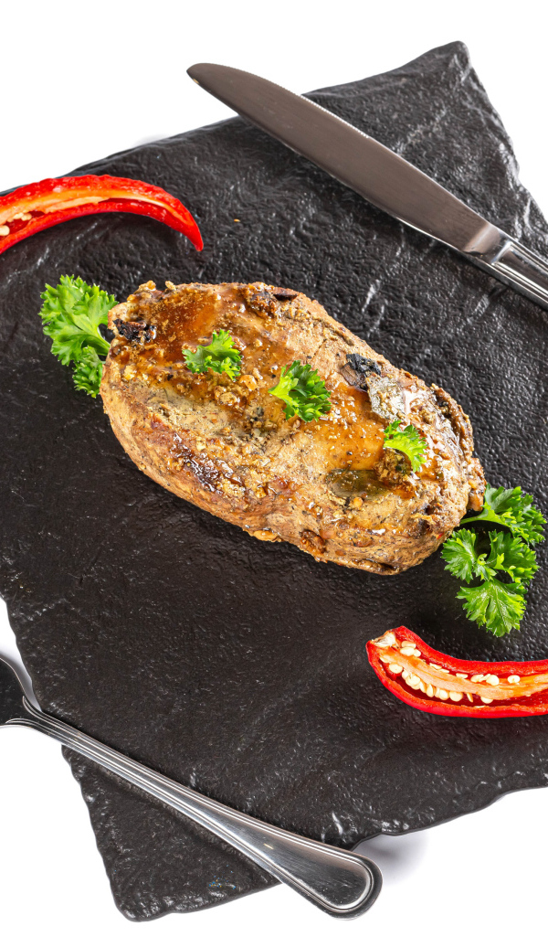 Кусок мяса с красным перцем на доске