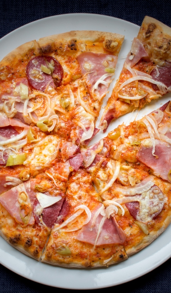 Нарезанная пицца на белой тарелке