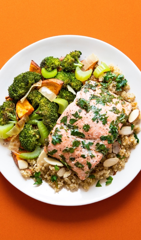 Вкусная рыба на тарелке с овощами и кашей