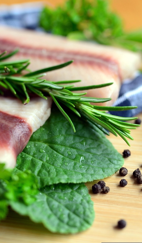 Свежая рыба на доске с зеленью и специями