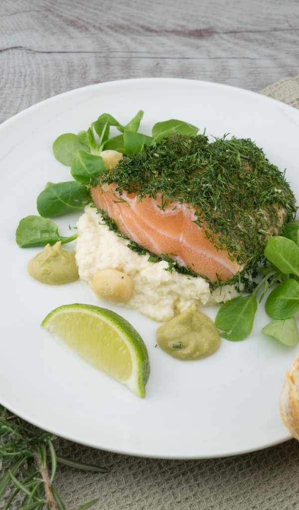 Кусок рыбы с зеленью на столе с хлебом