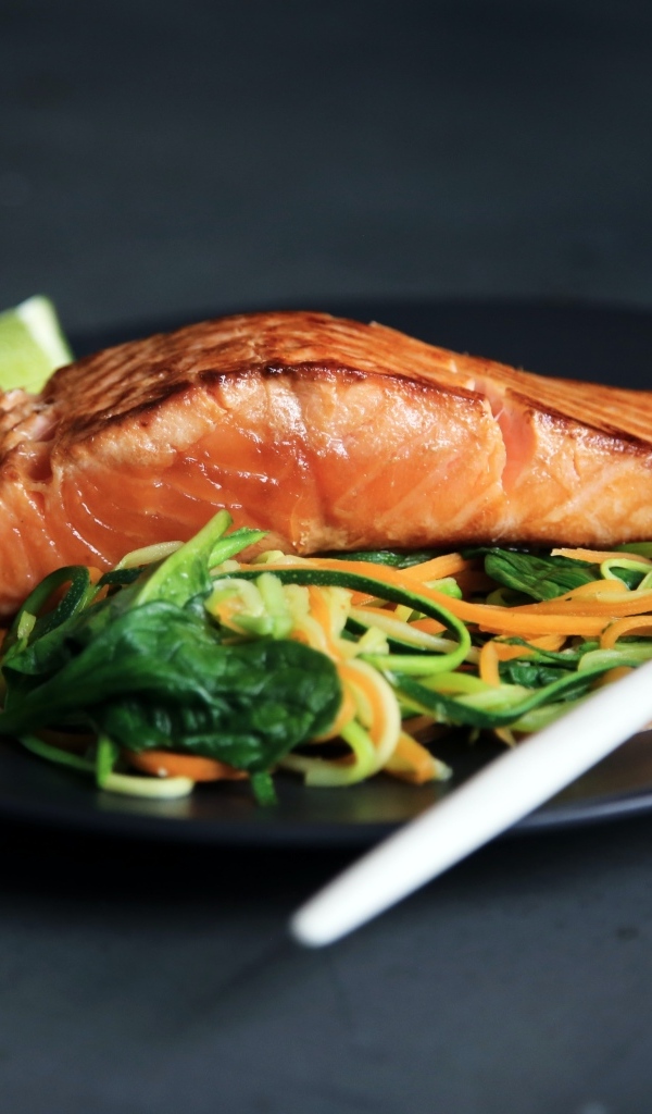 Кусок красной рыбы с салатом на тарелке