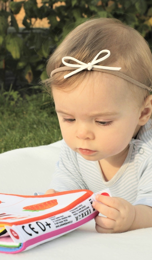 Маленькая девочка с книгой на природе