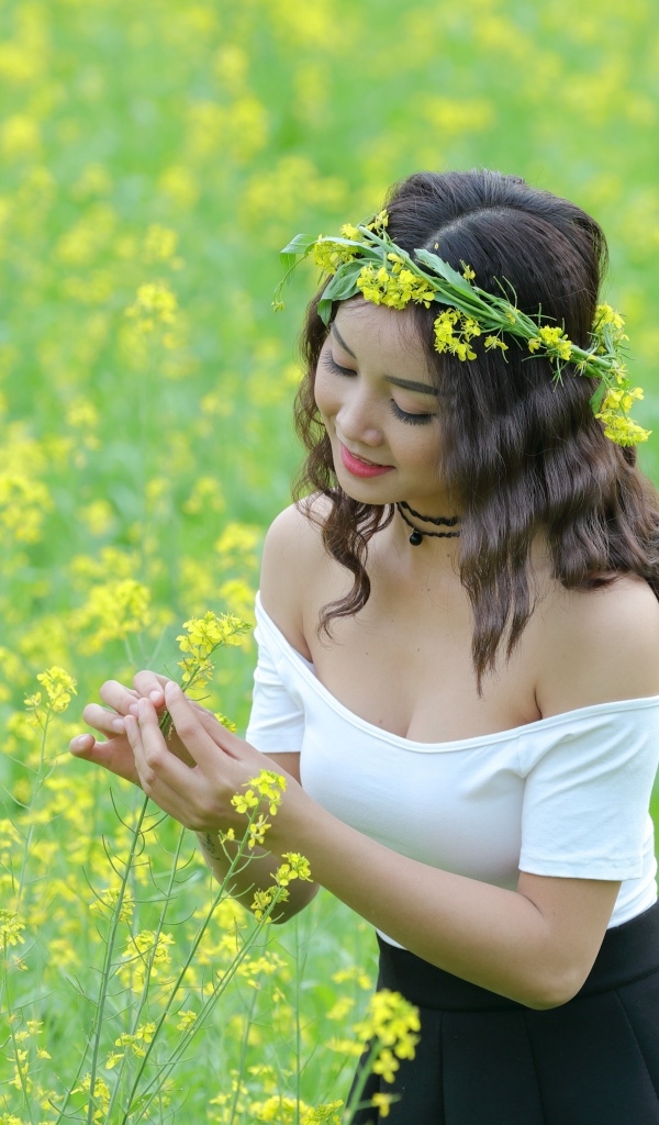 Девушка азиатка на рапсовом поле