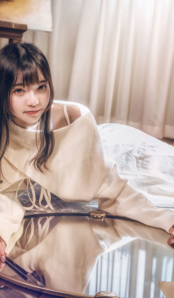 Девушка азиатка в белом платье лежит на полу