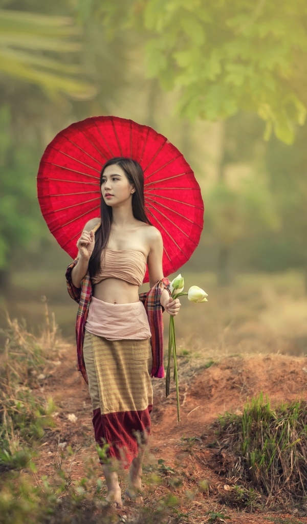 Девушка азиатка с красным зонтом и цветами лотоса