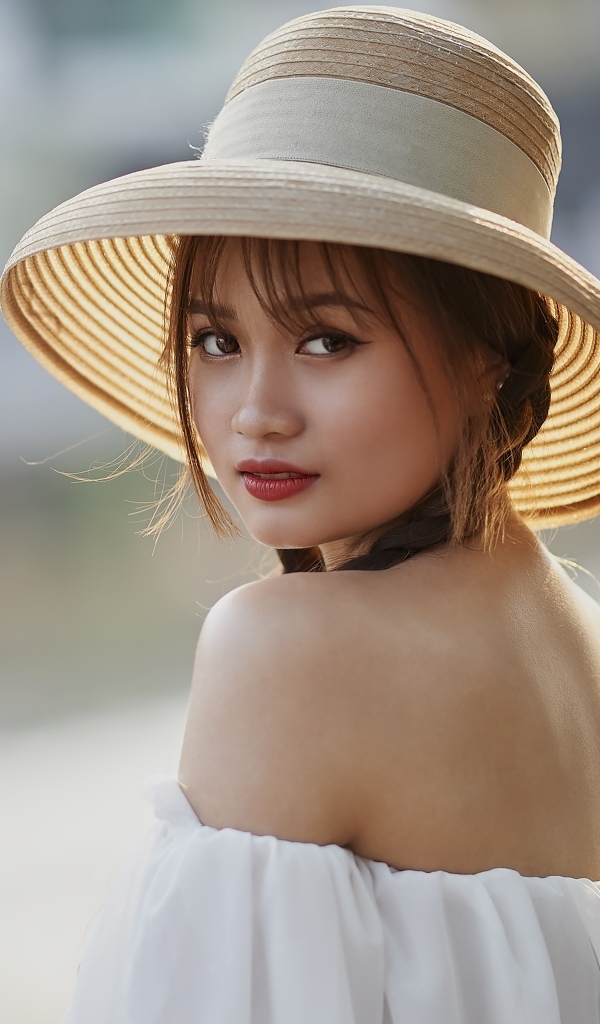 Красивая девушка азиатка в шляпе