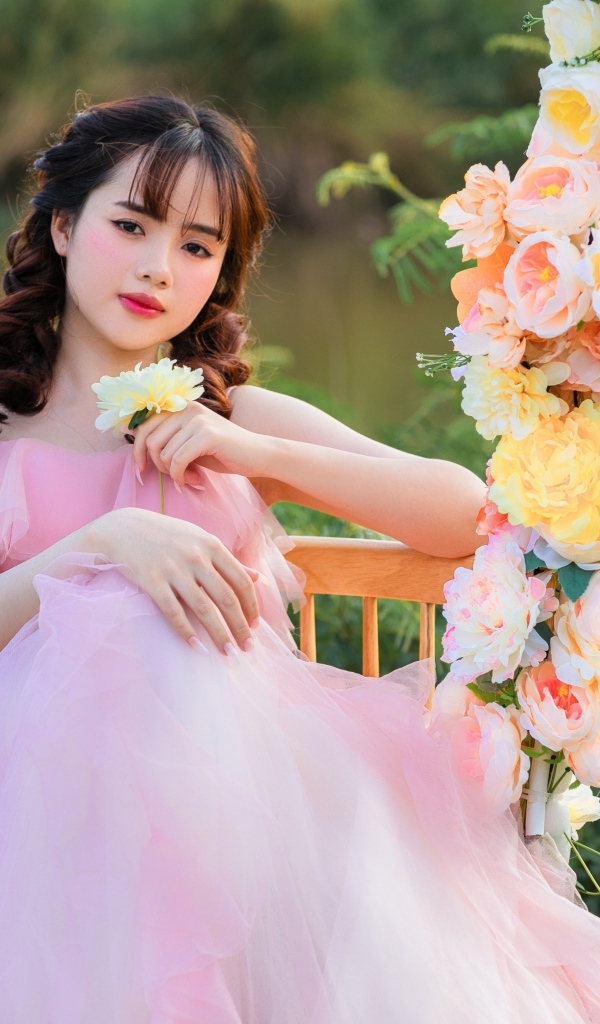 Красивая девушка азиатка в розовом платье с цветами