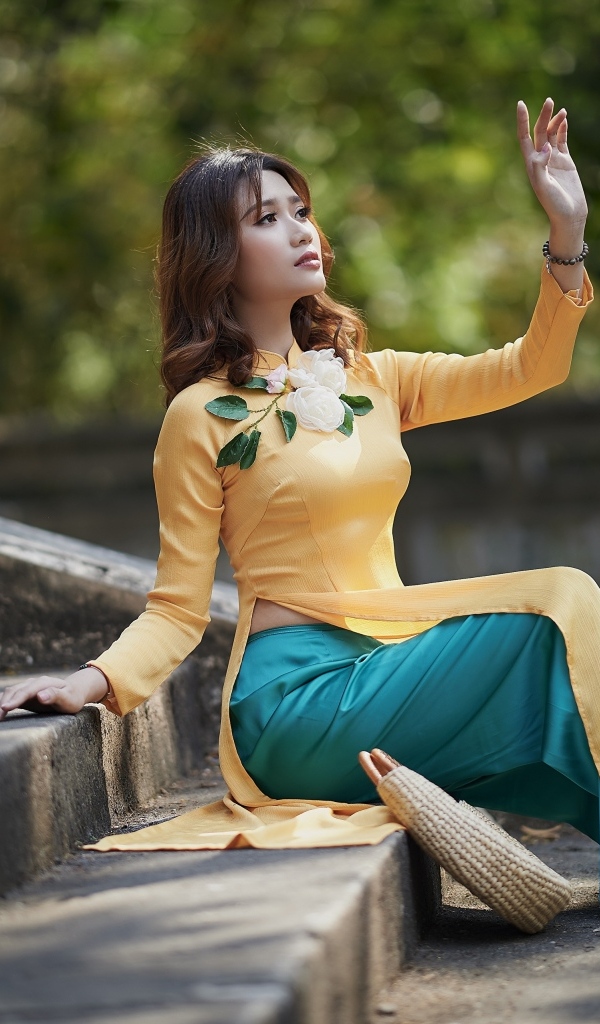 Красивая девушка азиатка сидит на ступеньках