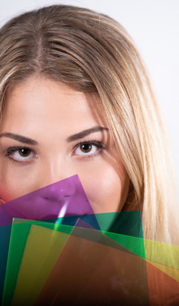 Красивая кареглазая девушка с разноцветной бумагой