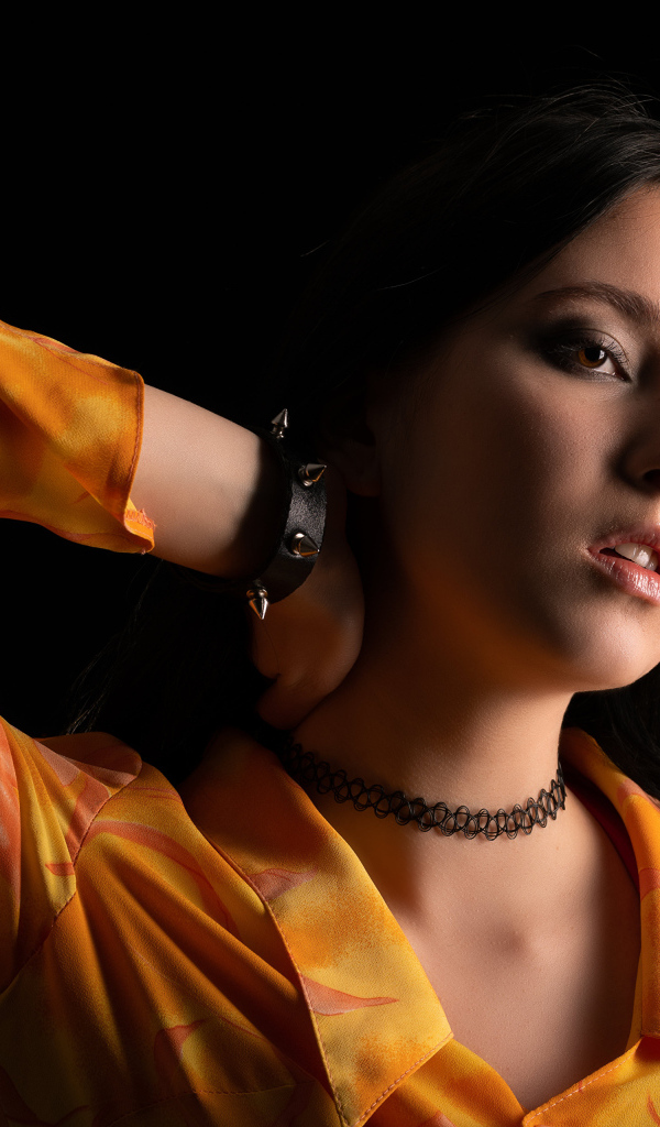 Красивая девушка шатенка с рукой в волосах на черном фоне