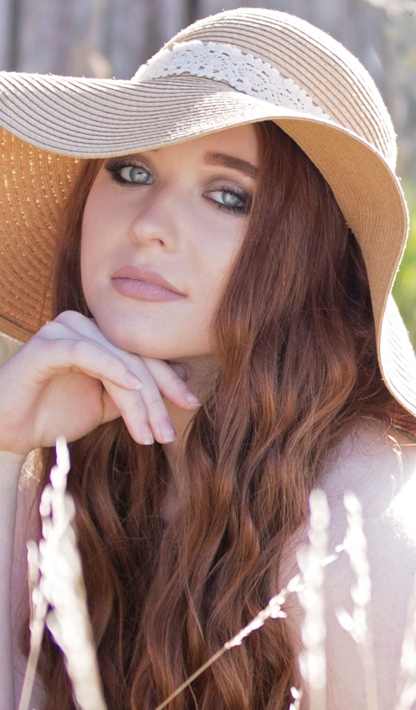 Красивая девушка в большой шляпе 