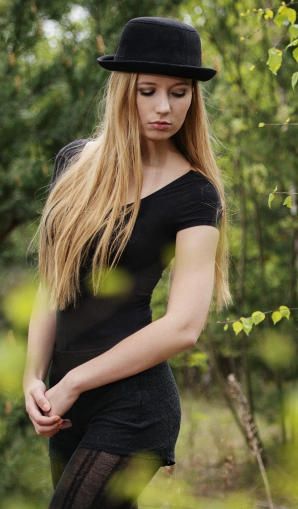 Красивая девушка в черном наряде в шляпе