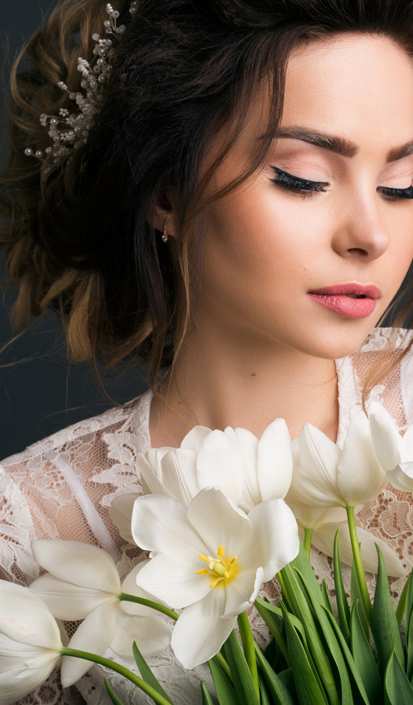 Красивая девушка с букетом белых тюльпанов на сером фоне