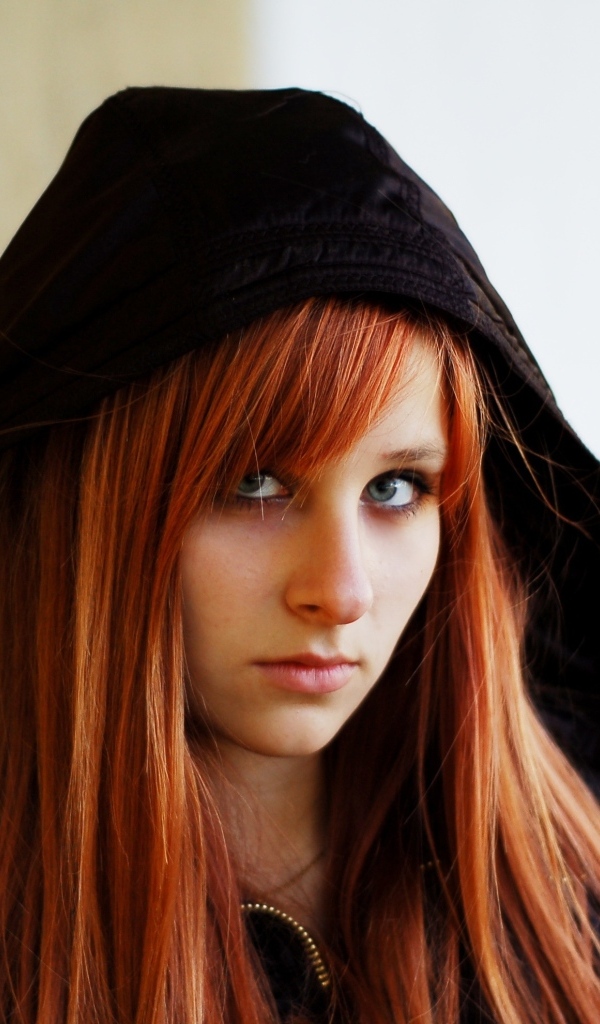 Красивая рыжеволосая девушка в черном балахоне