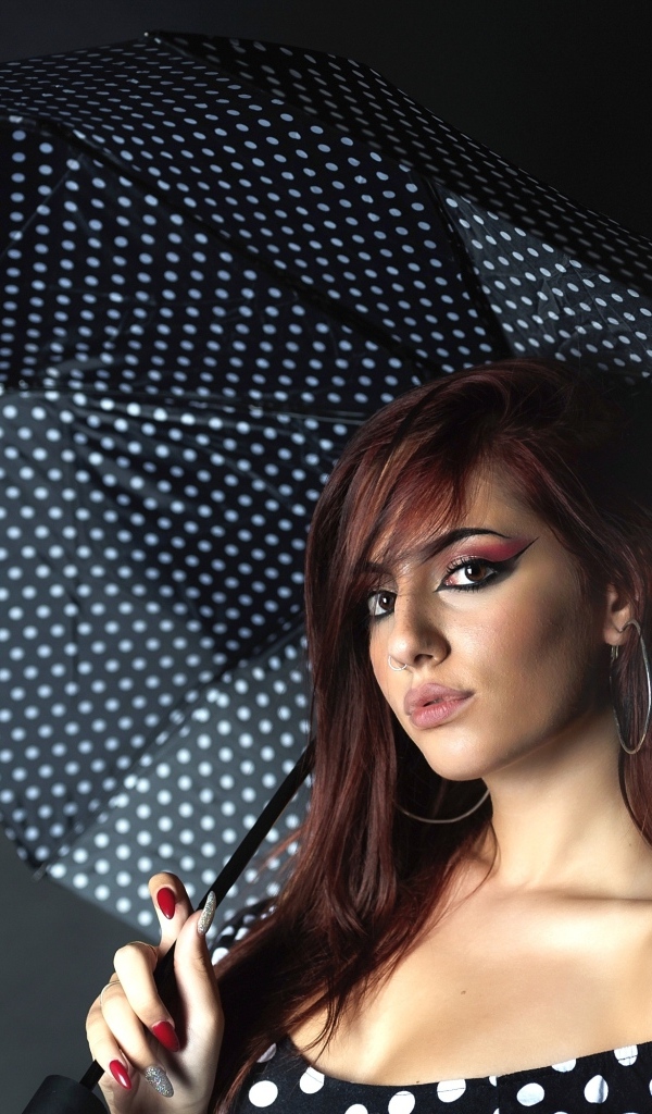 Яркая девушка под зонтом на сером фоне