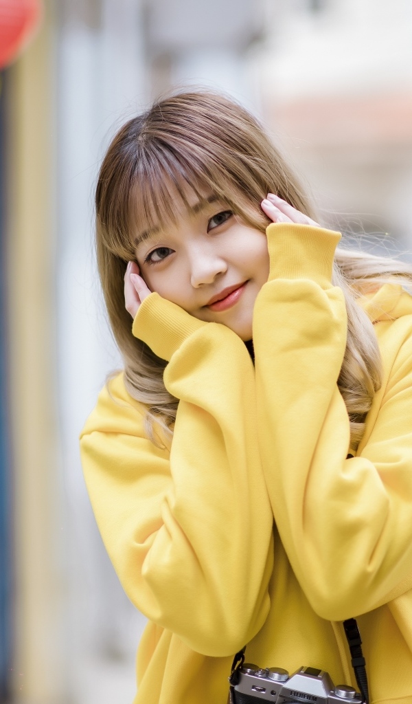 Милая девушка азиатка в желтом свитере