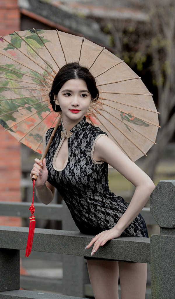 Симпатичная девушка азиатка с зонтом в руках