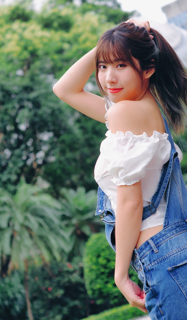 Милая девушка азиатка в джинсовом комбинезоне