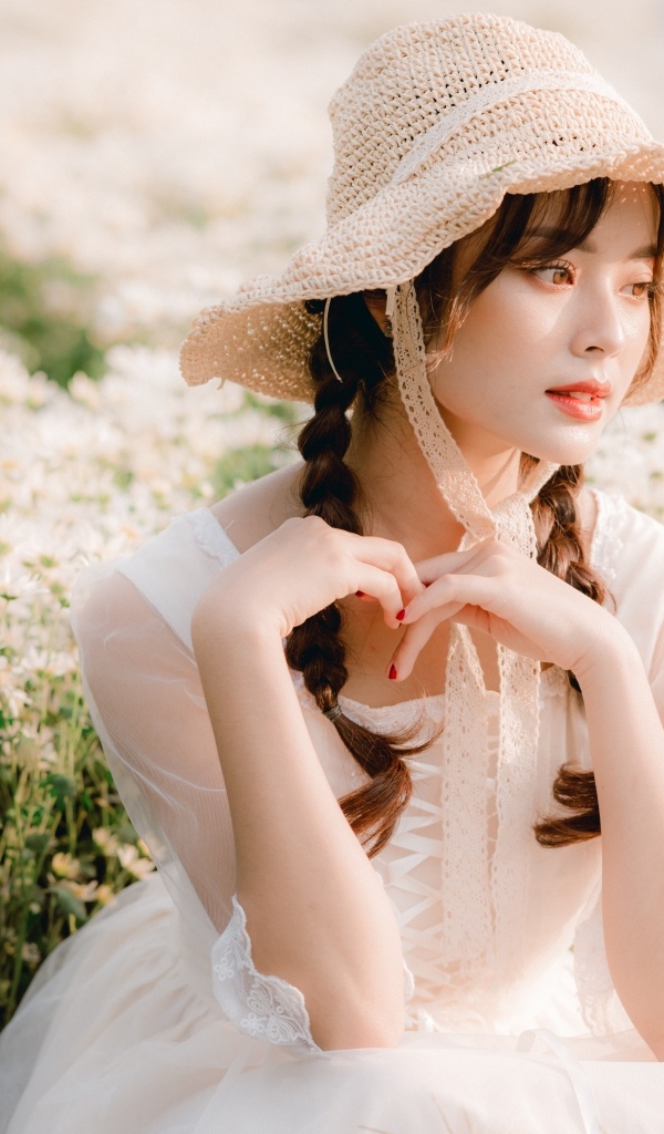 Милая азиатка в шляпе и белом платье 