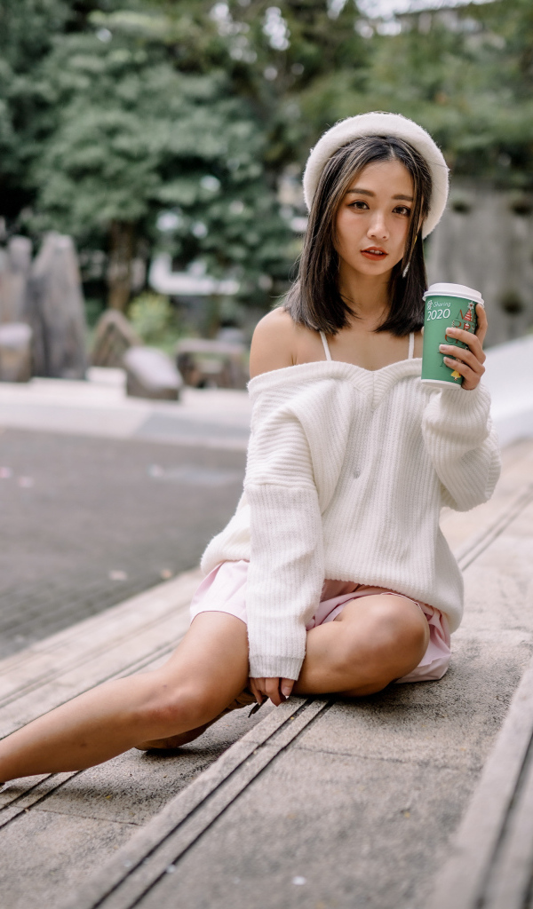 Милая азиатка в с кофе в руках 