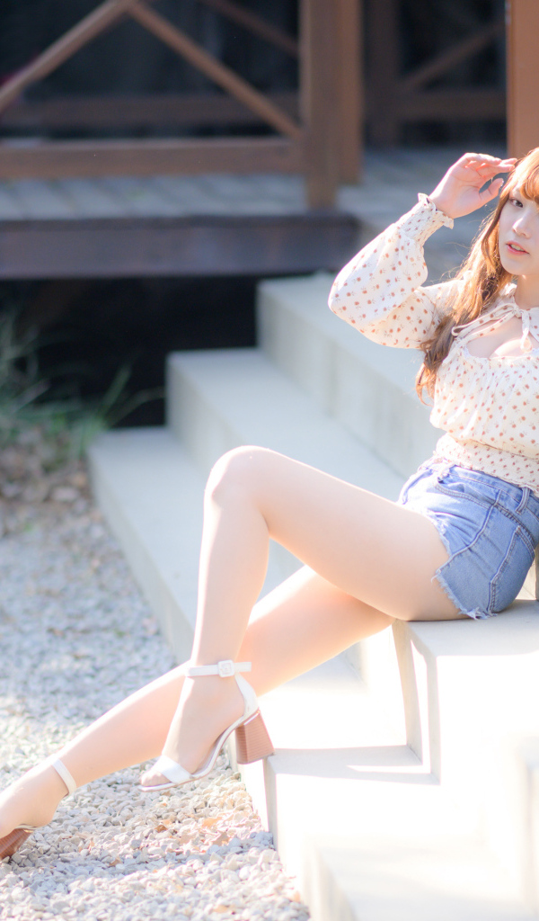 Милая настоящая азиатка сидит на ступеньках