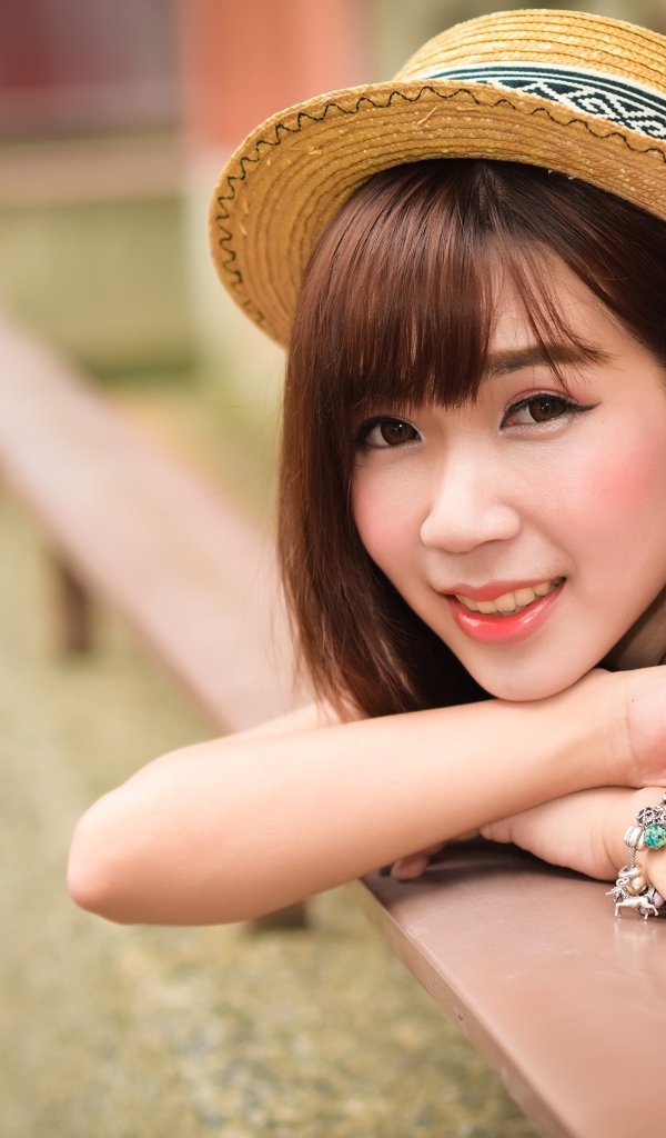 Милая улыбка азиатки в соломенной шляпе 