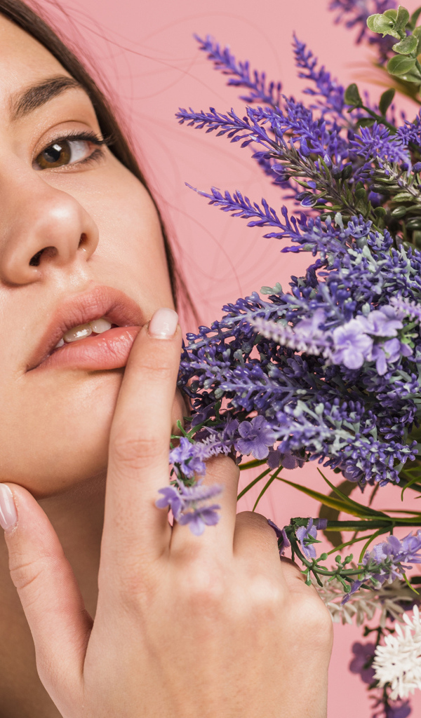 Милая молодая девушка с букетом полевых цветов