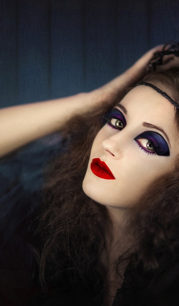 Девушка в черном наряде с ярким макияжем