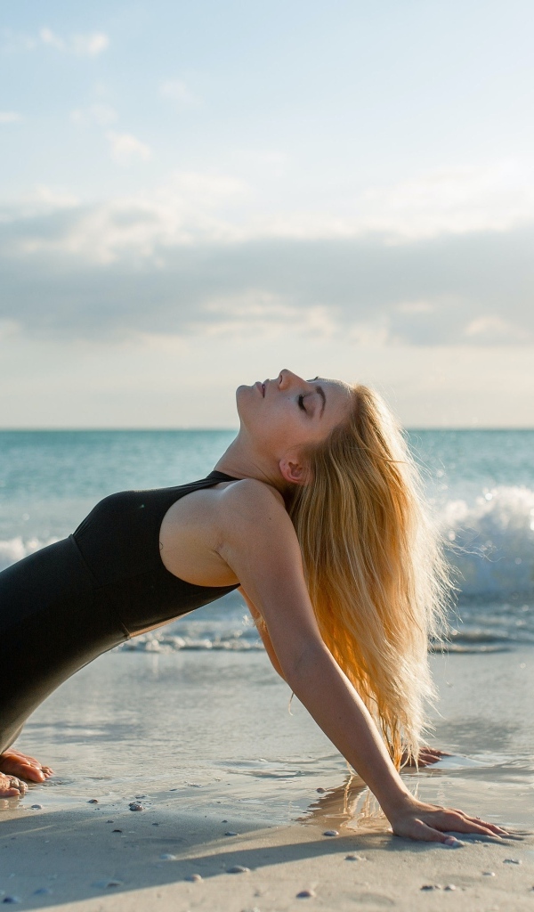 Девушка в черном купальнике на берегу моря
