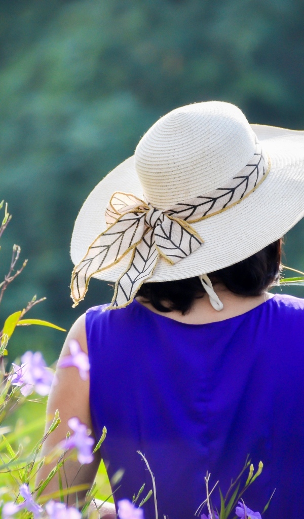 Девушка в шляпе с букетом полевых цветов
