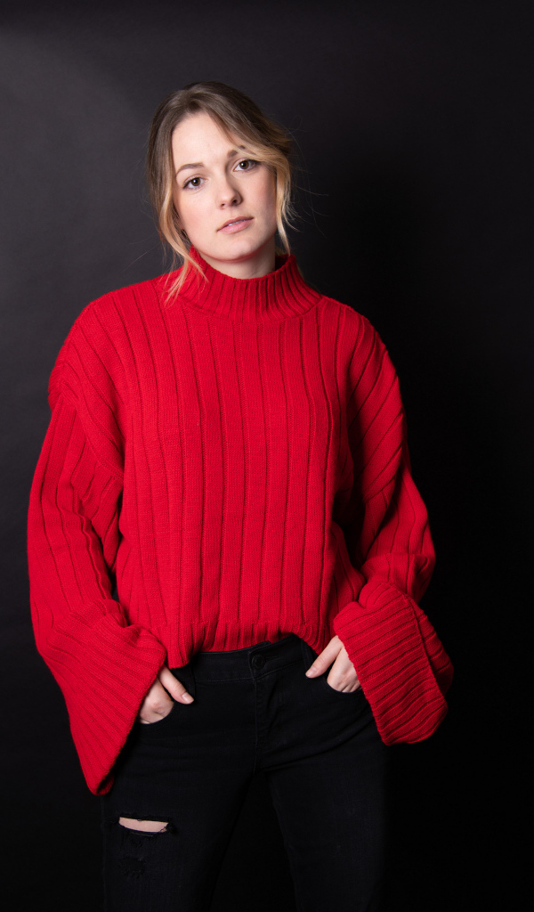 Девушка в красном свитере на черном фоне