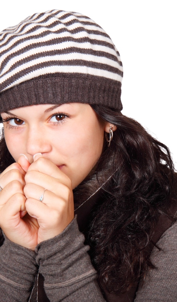 Девушка в теплой полосатой шапке на белом фоне