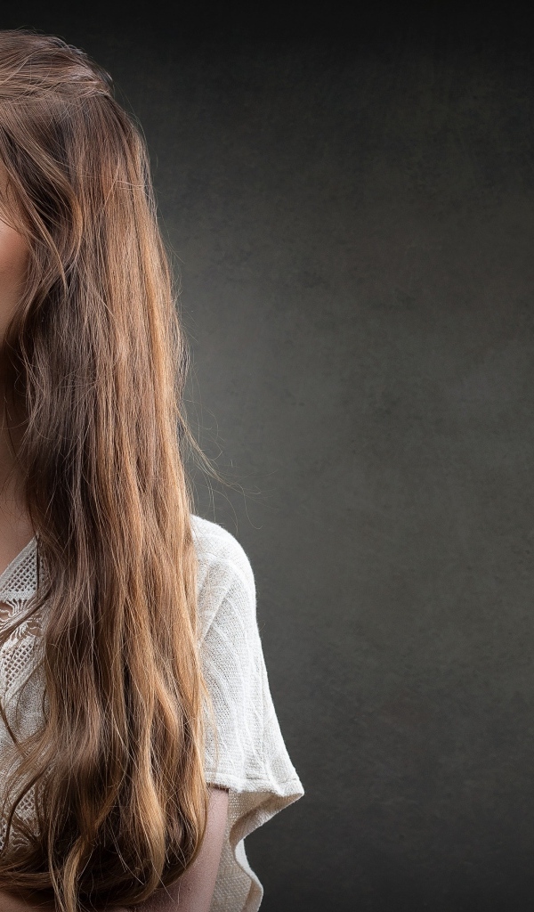 Девушка в белом платье с длинными волосами на сером фоне