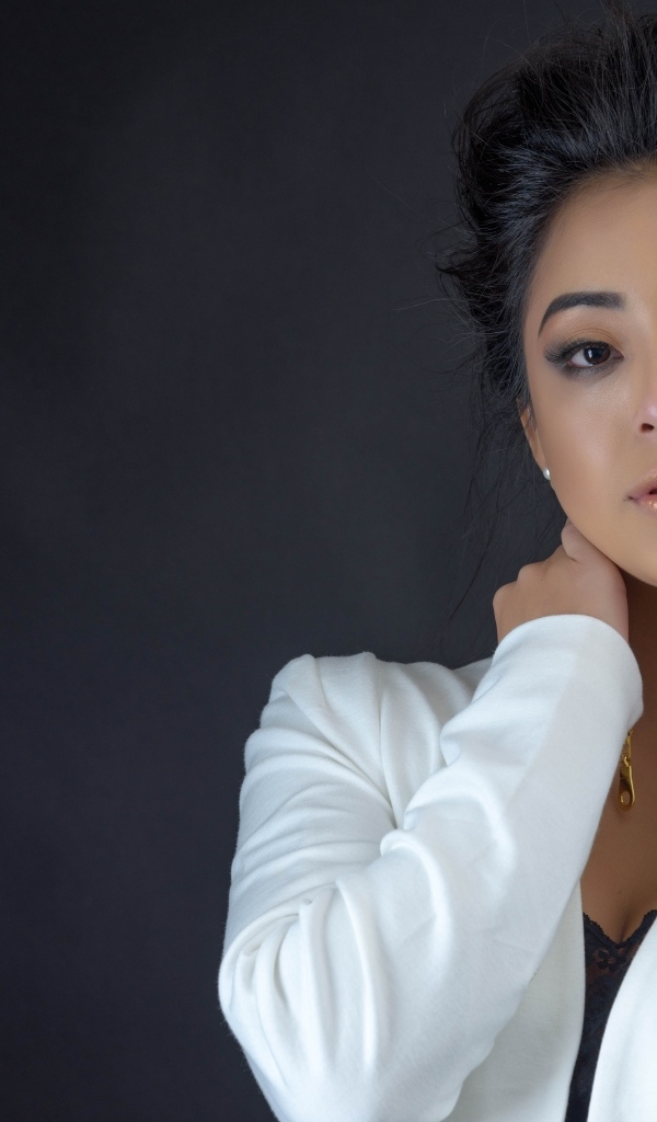 Девушка в белой кофте на сером фоне