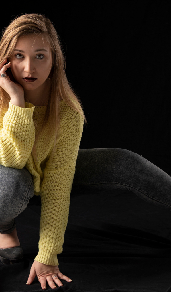 Девушка в желтом свитере на черном фоне