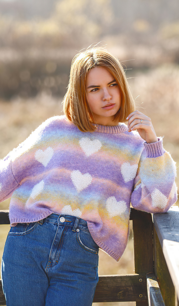 Девушка в свитере и синих джинсах